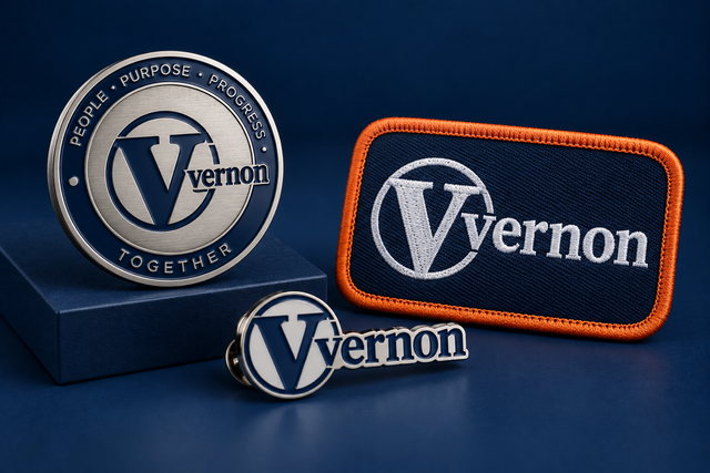An engraved recognition coin, embroidered patch, and lapel pins